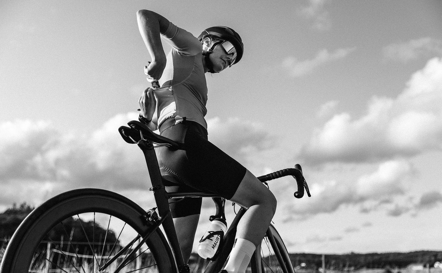 kvinde ligger maurten gel i baglommen på hendes cykel jersey