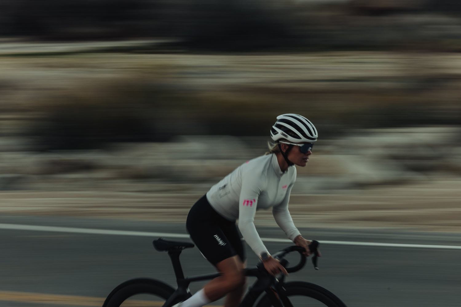 kvinde cykler gennem ørken med 100% cykelbriller