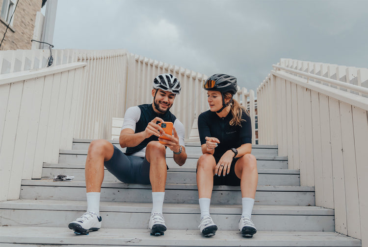 to personer sidder på en trappe i cykeltøj og bont motion cykelsko
